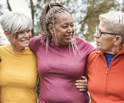 group of older women outside arm in arm smiling