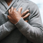 African American Man holding chest pain heart