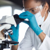 scientist looks through microscope