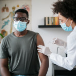 black patient man getting vaccine face mask covid coronavirus