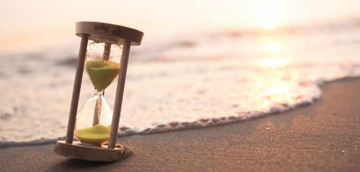 hourglass on the beach at waters edge