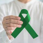 hand with green ribbon cerebral palsy and liver cancer awareness