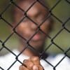 african american boy behind fence
